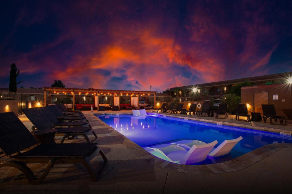 a swimming pool with lounge chairs and a building with a fire at GreenTree Inn Sedona in Sedona