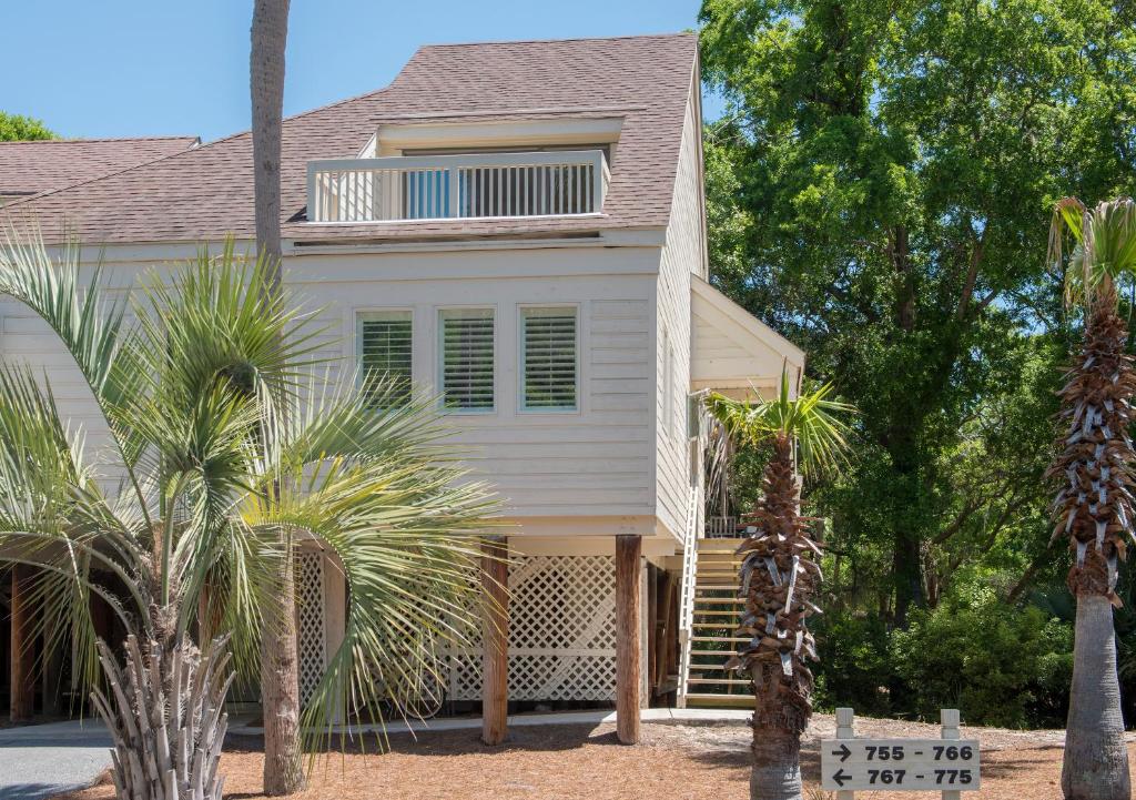 a white house with palm trees in front of it at 770 Spinnaker Beach House in Seabrook Island