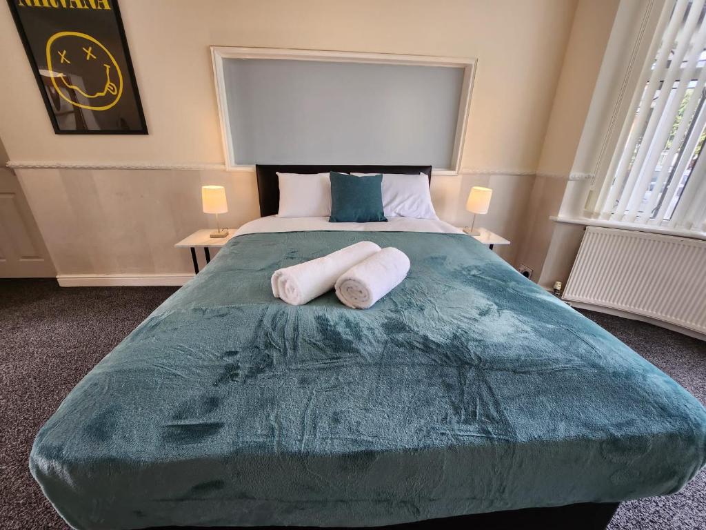 a bedroom with a large bed with two towels on it at Sheldon Shared House in Birmingham