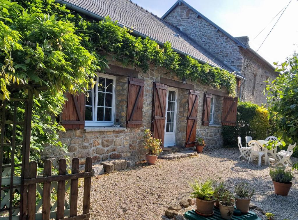 a stone cottage with a fence and plants at La saunière - Chez Hélène - Gîtes en baie in Champeaux