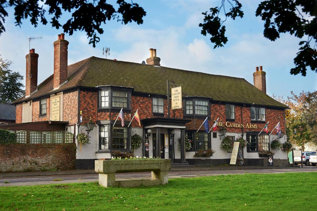 un grand bâtiment en briques avec des drapeaux devant lui dans l'établissement Camden Arms Hotel, à Royal Tunbridge Wells