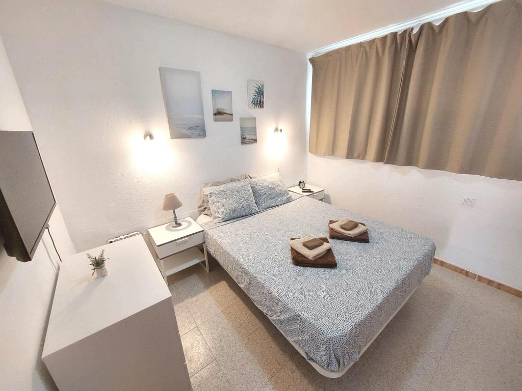 a small bedroom with a bed and two night stands at Sun apartment Antigua in Costa de Antigua