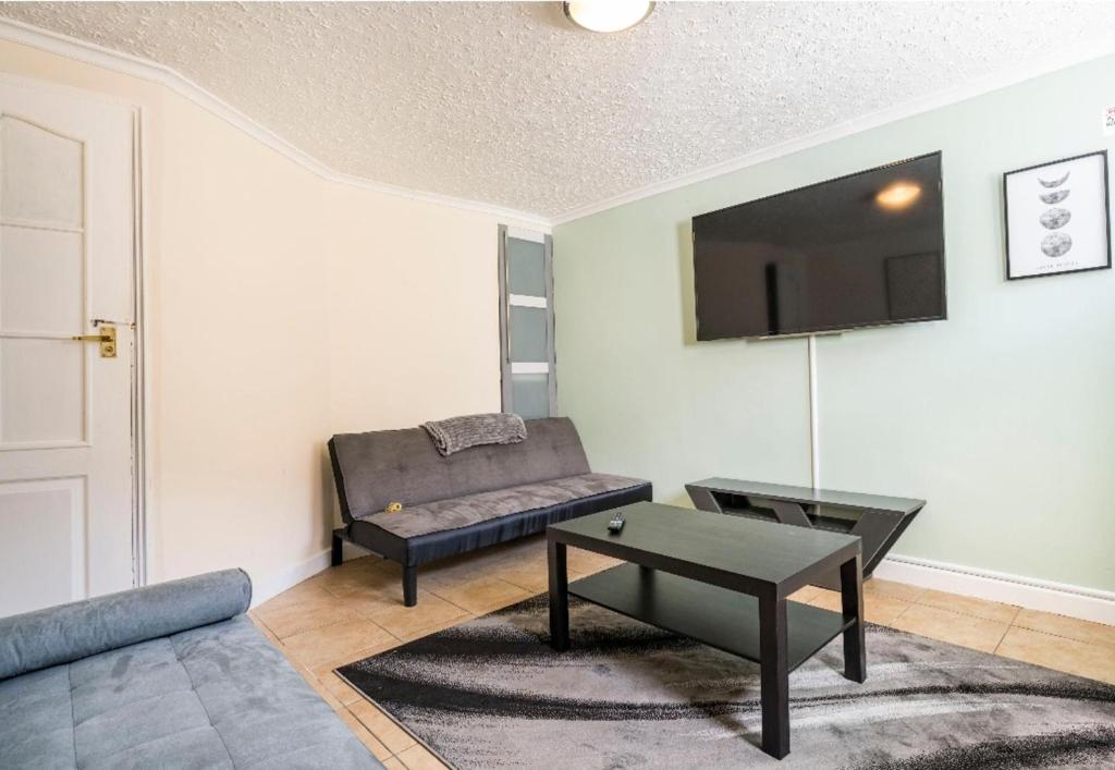 - un salon avec un canapé et une table dans l'établissement Maidstone castle 3bedroom free sports free parking, à Maidstone