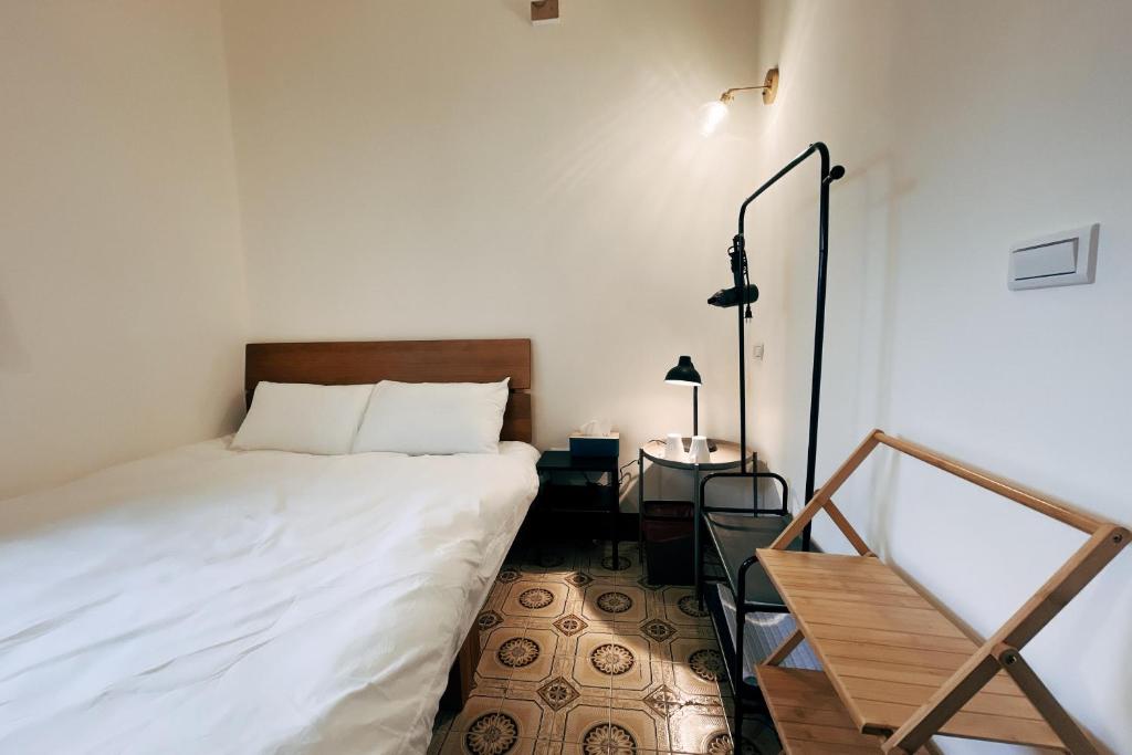 Postel nebo postele na pokoji v ubytování 鴉埠客棧x南華大旅社