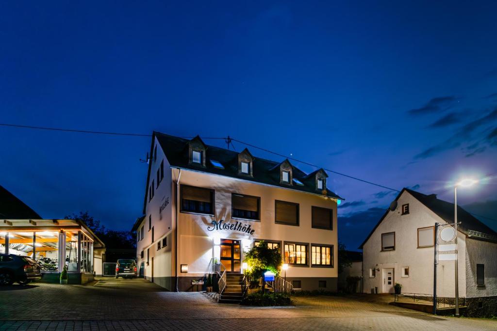 a building with a sign on it at night at Landgasthaus Moselhöhe in Liesenich