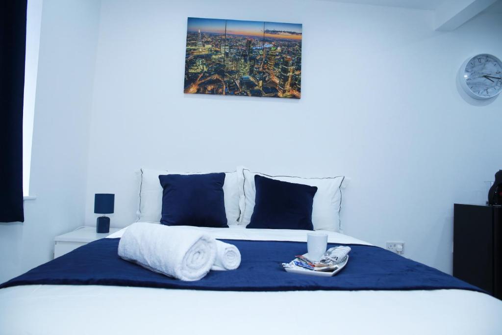 una camera da letto con un letto e asciugamani di Lovely Apartment with free parking on premises. a Londra