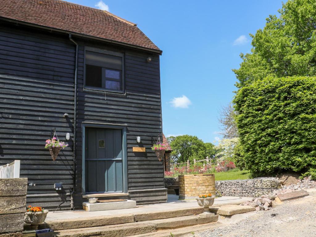 una casa negra con una puerta y un patio en The Masters House en Hassocks