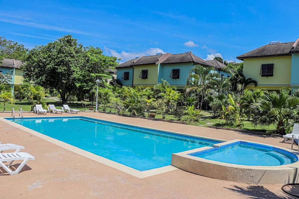 a swimming pool in front of a house at Water Mills- Beach Apartments in Mammee Bay