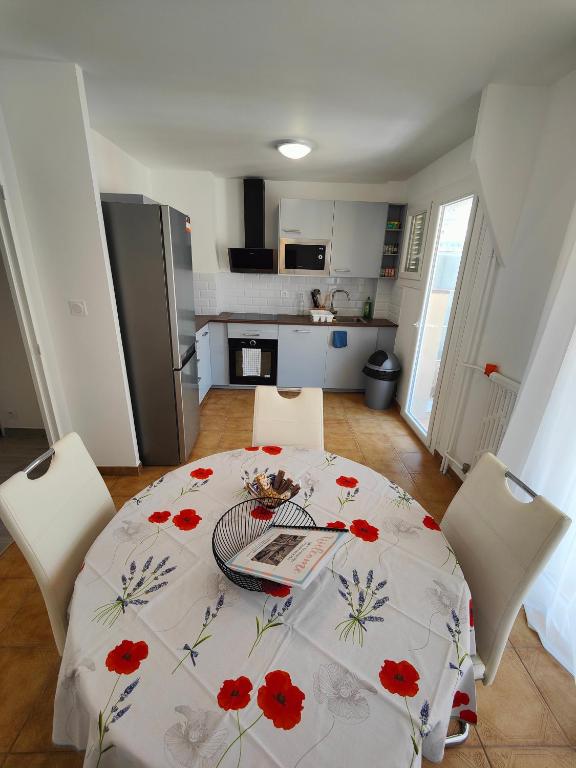 - une cuisine avec une table ornée de fleurs rouges dans l&#39;établissement Charmant appartement au cœur de Nice - proche de tout !, à Nice