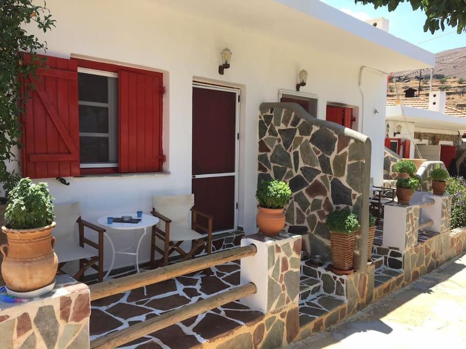 un portico di una casa con piante in vaso di red2 guest house a Flampouria
