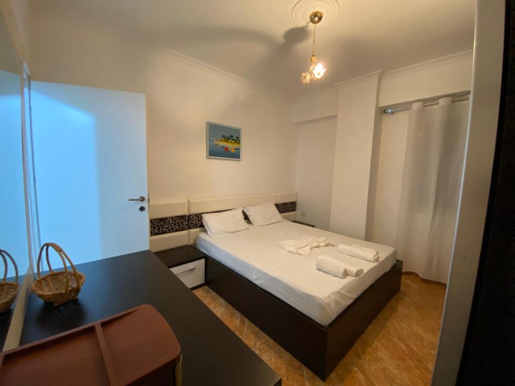 a small bedroom with a bed and a desk at The Blue Pearl Apartment in Durrës