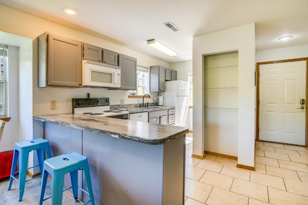 a kitchen with a counter and two stools at Branson Escape with Pool Access, Grill and Balcony! in Branson