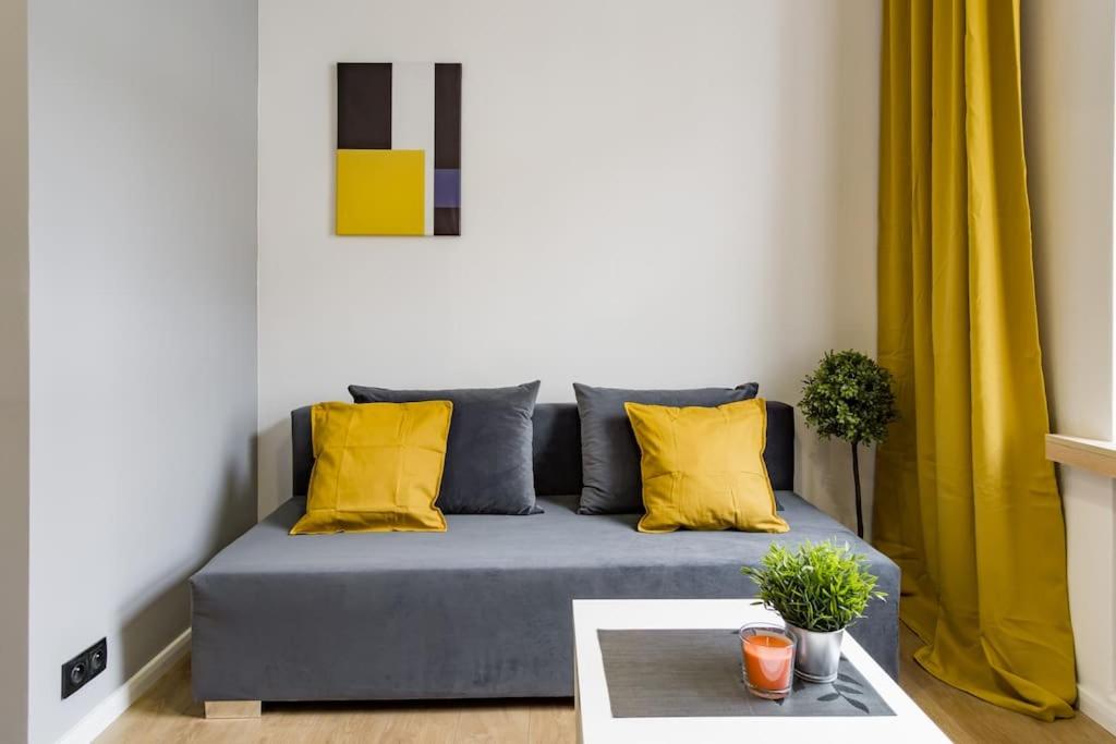un divano blu con cuscini gialli in soggiorno di Kawalerka w Śródmieściu 24 a Łódź