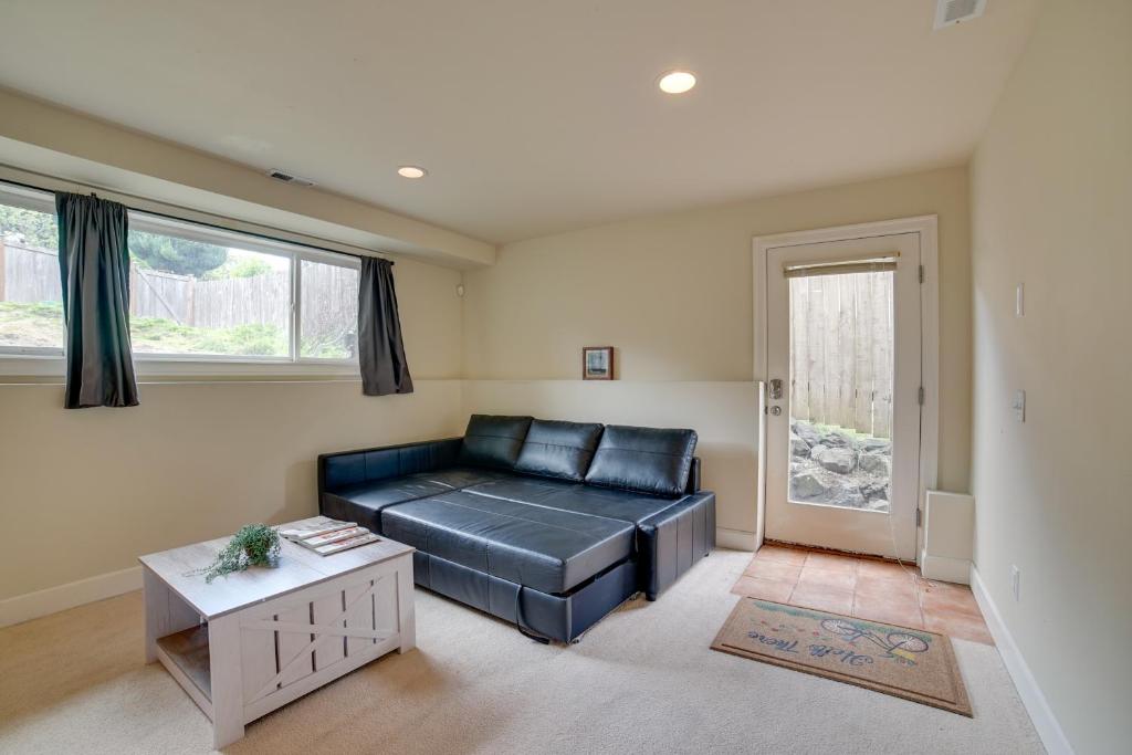 uma sala de estar com um sofá de couro preto e uma mesa em Airy Seattle Apartment about 7 Mi to Downtown! em Seattle