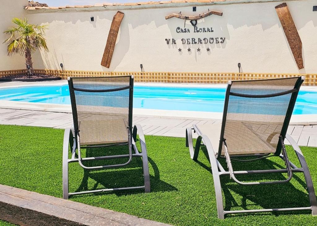 2 sillas sentadas junto a una piscina en casa rural valderaduey, 