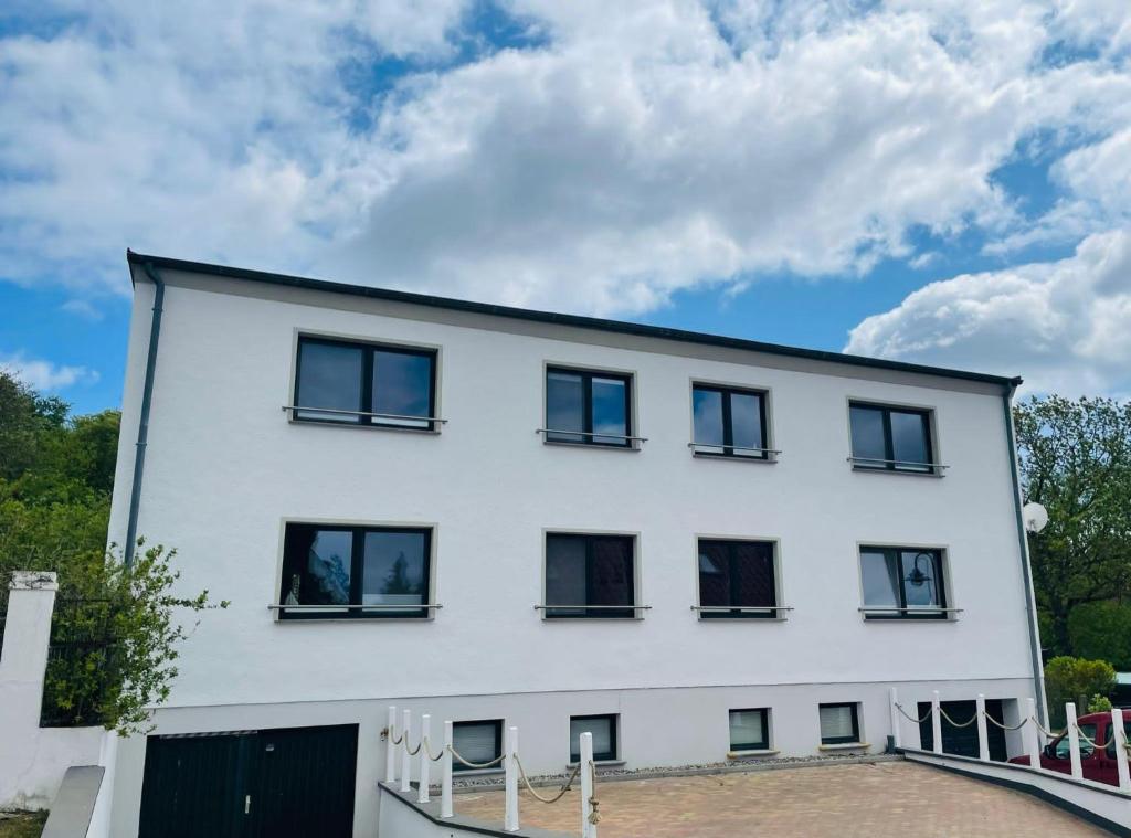 ein weißes Gebäude mit schwarzen Fenstern und einem Himmel in der Unterkunft Ferienhaus Fiete 2 in Sagard