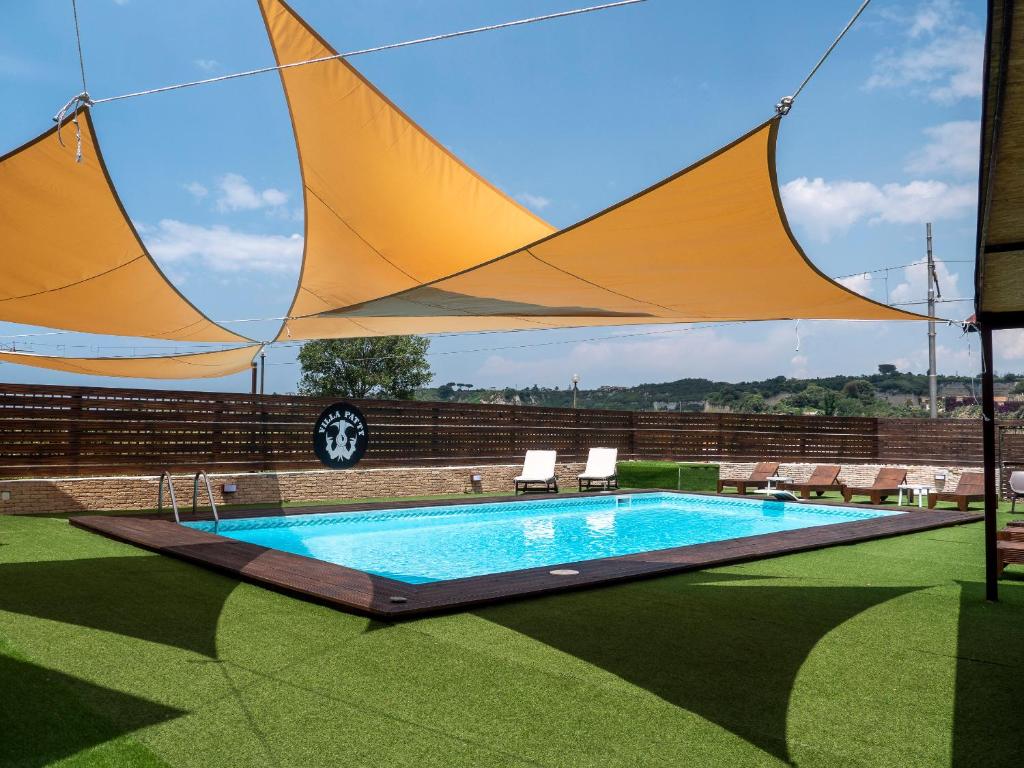 a swimming pool with a large yellow sail over it at Villa Patty in Naples
