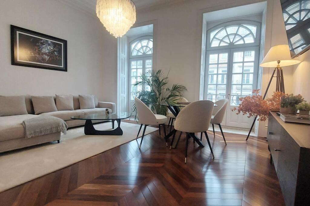 a living room with a couch and a table and chairs at Dream on - Clérigos Tower in Porto
