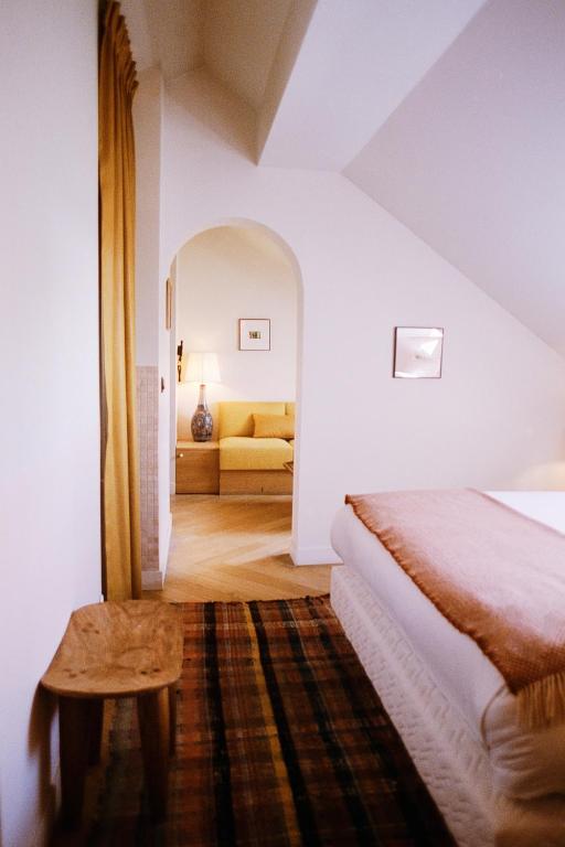 une chambre avec un lit et un canapé dans une pièce dans l'établissement Hotel Habituel, à Paris