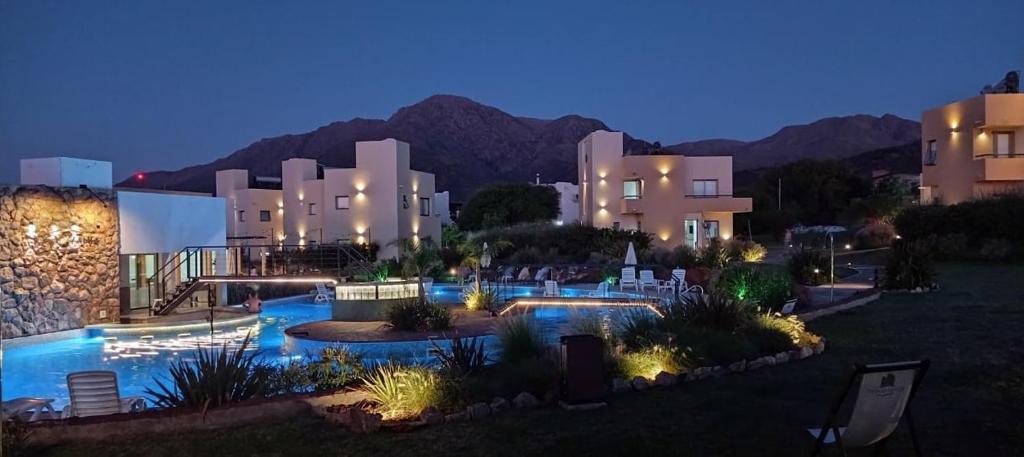 a resort with a swimming pool at night at Apart Hotel Los alazanes in Capilla del Monte