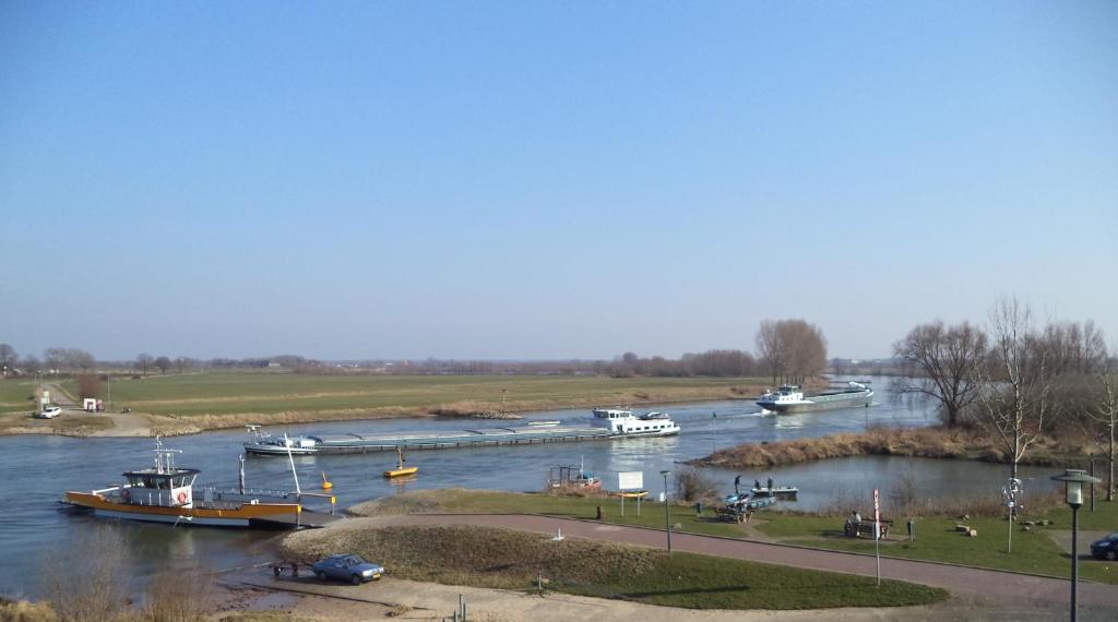 um grupo de barcos ancorados num rio em Aan Het Veer minimaal 4 overnachtingen em Dieren