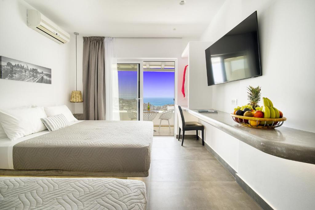 Pokój hotelowy z łóżkiem i biurkiem z misą owoców w obiekcie Anius Apartments w mieście Mykonos