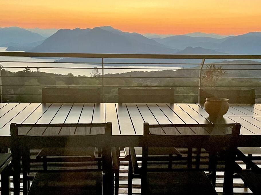 a table on a balcony with a view of the mountains at Lakeview Apartment Lago Maggiore in Gignese
