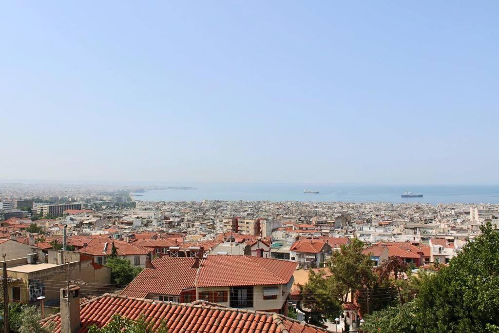uitzicht op een stad met gebouwen en de oceaan bij Thea Apartment in Thessaloniki