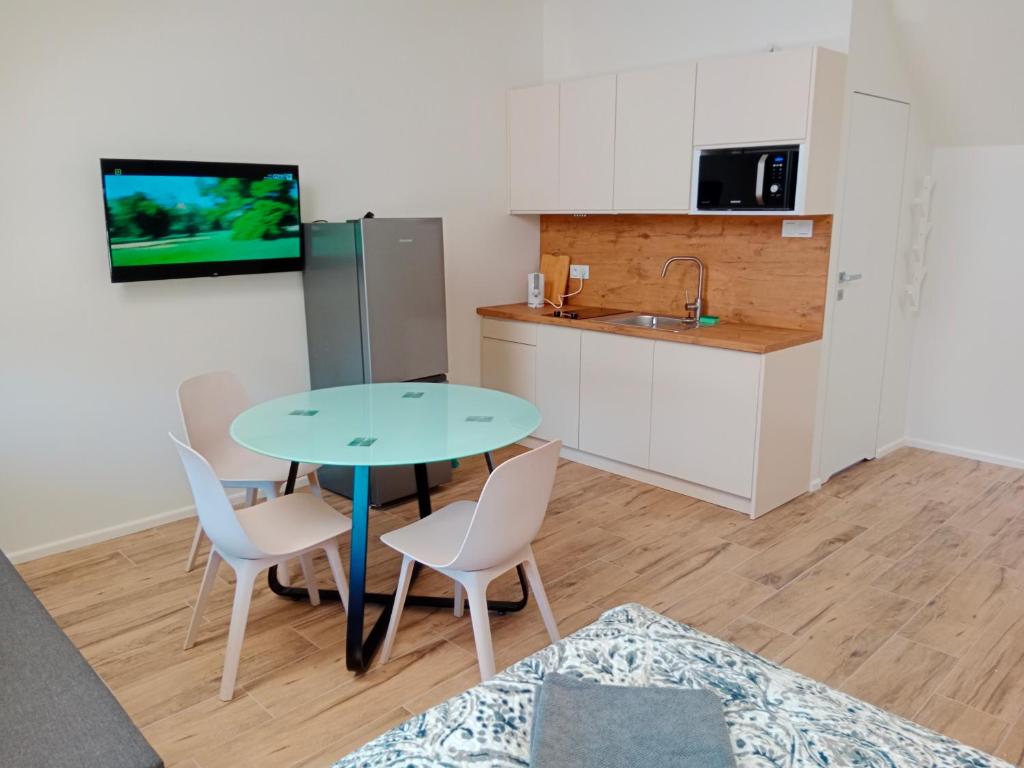 a kitchen and a table and chairs in a room at Apartamenty Elbląska 20A in Braniewo