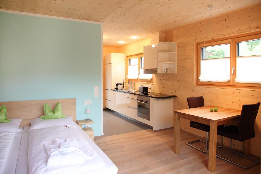 a bedroom with a bed and a table and a kitchen at ZeiTraum Ferienwohnung Hohe Stein in Elzach