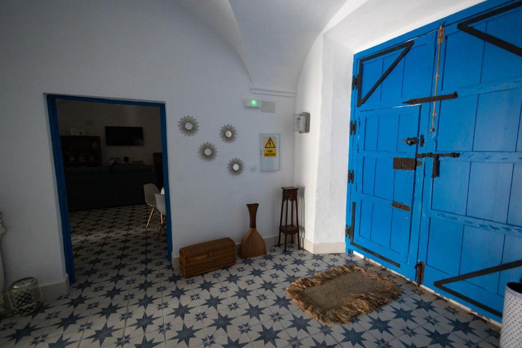 a large blue door in a room with a floor at El palacete azul in Almendral