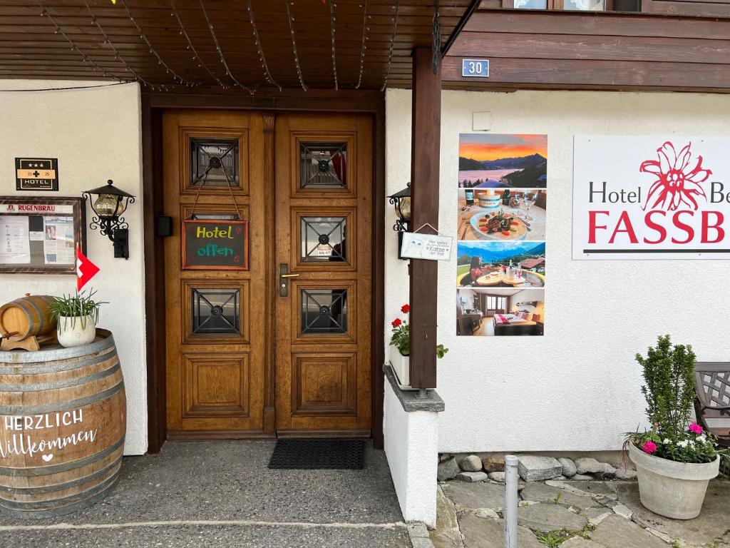 a wooden door of a building with a barrel next to it at Hotel Fassbind Beausite in Beatenberg