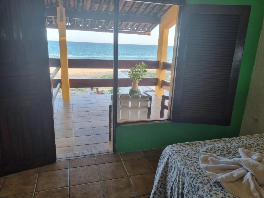 a bedroom with a view of the ocean at Pousada Princesa do Mar in Tamandaré