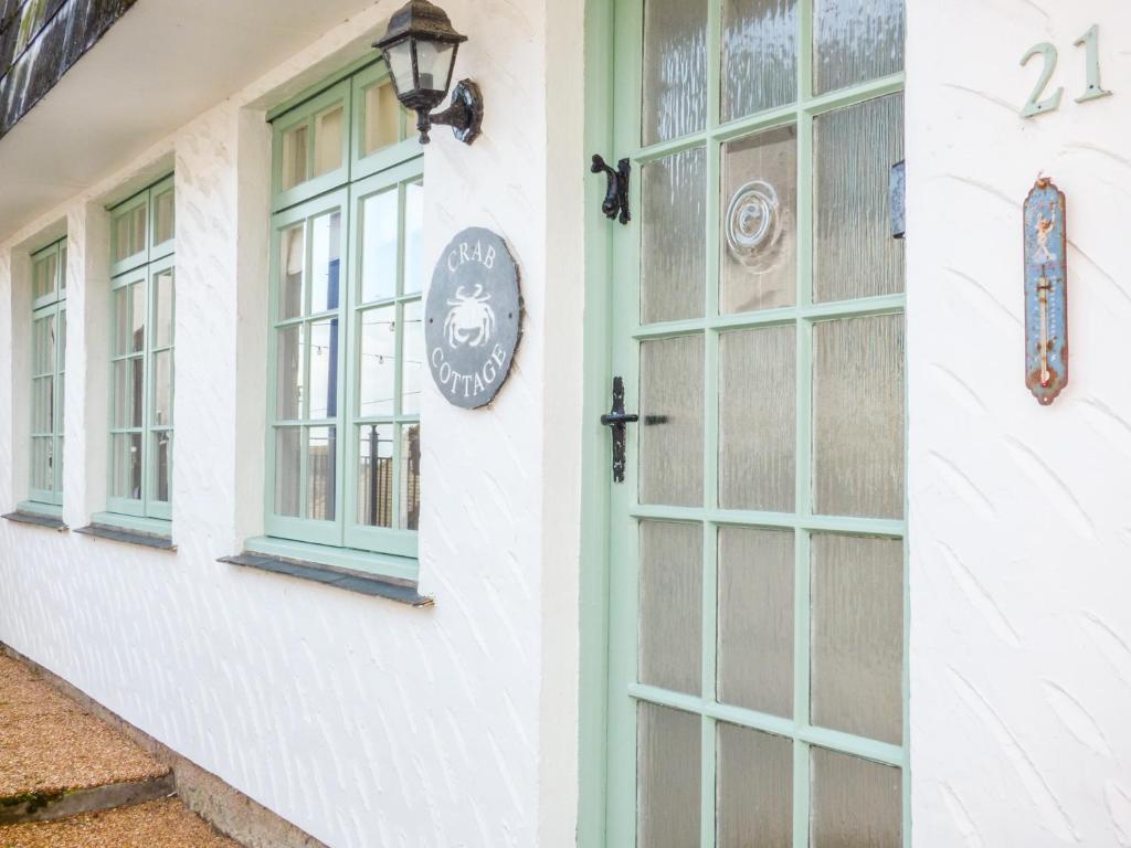 un edificio con ventanas y un reloj lateral en Crab Cottage, en Ilfracombe