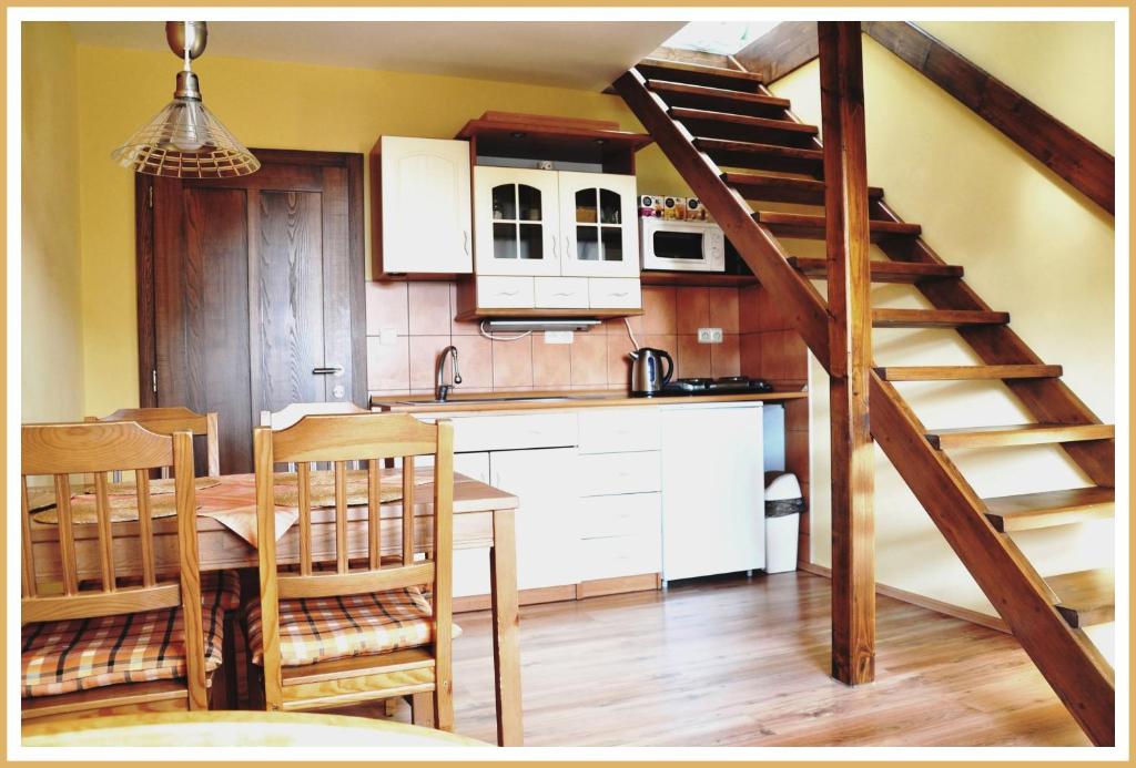 a kitchen with a table and a kitchen with a staircase at Apartmány Fišerovi in Vysoké nad Jizerou