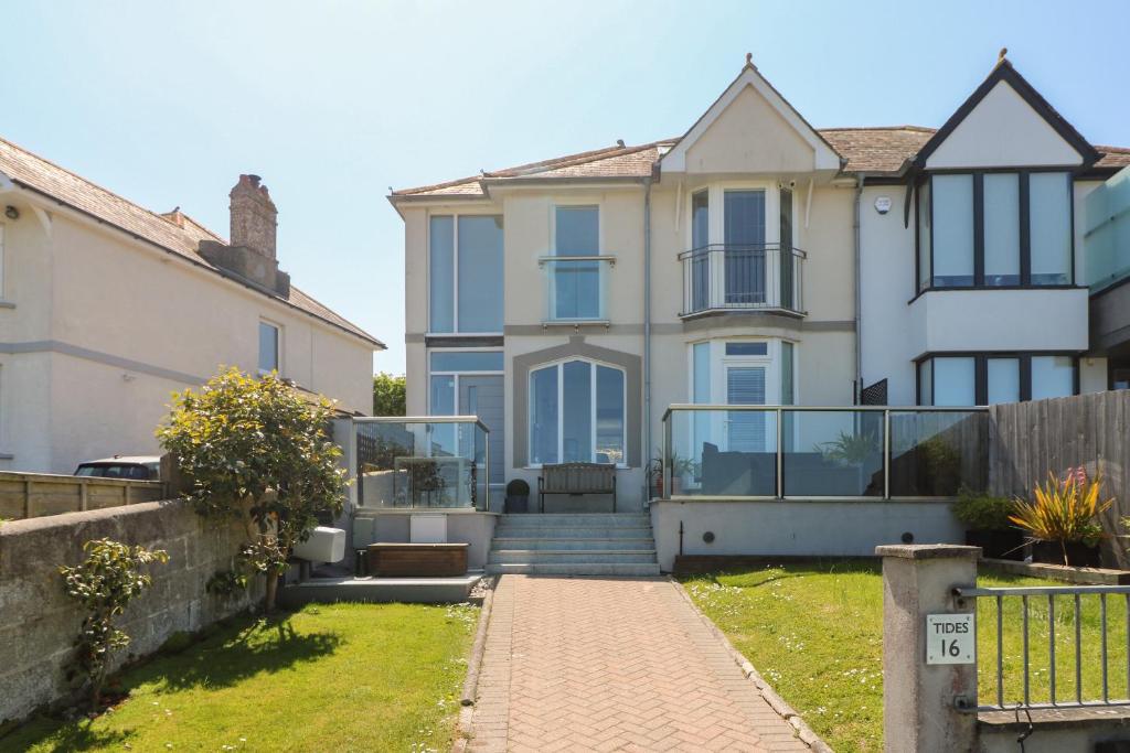 a large white house with a fence at Tides in Padstow