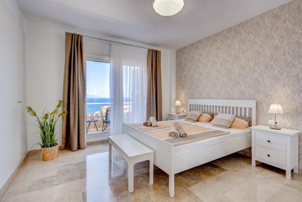 - une chambre avec un grand lit et une grande fenêtre dans l'établissement Casa del Sol, à Puerto de Santiago
