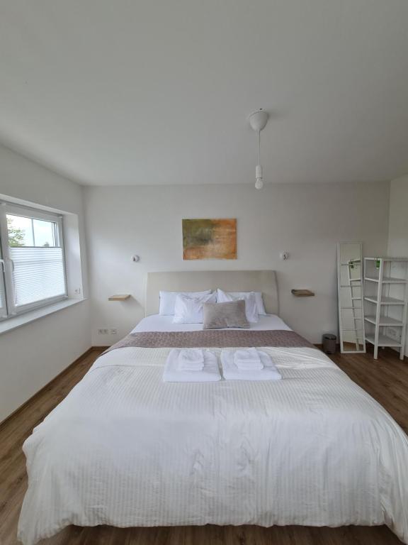 a bedroom with a large white bed with two towels on it at Private Zimmer in Neubau Familienhaus in Alsfeld