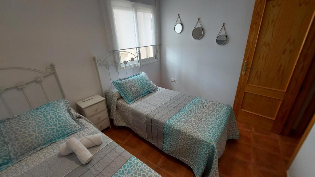 niewielka sypialnia z 2 łóżkami i drzwiami w obiekcie Apartamento con vistas a la piscina y al castillo templario w mieście La Iruela