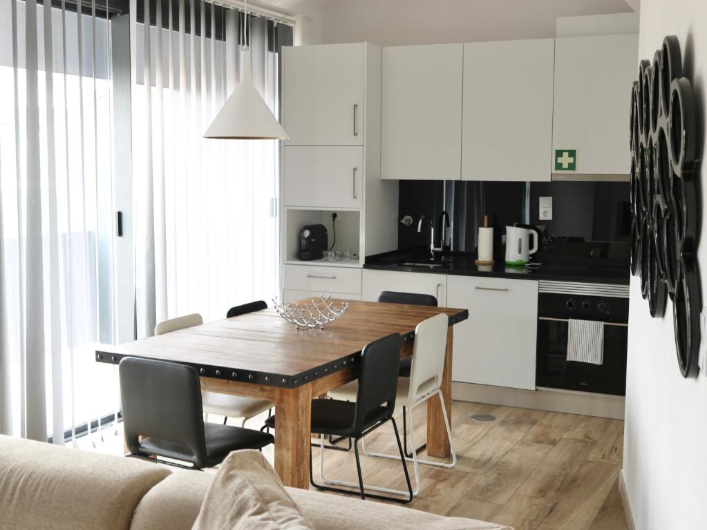 een keuken en eetkamer met een houten tafel en stoelen bij Up iConik in Aveiro