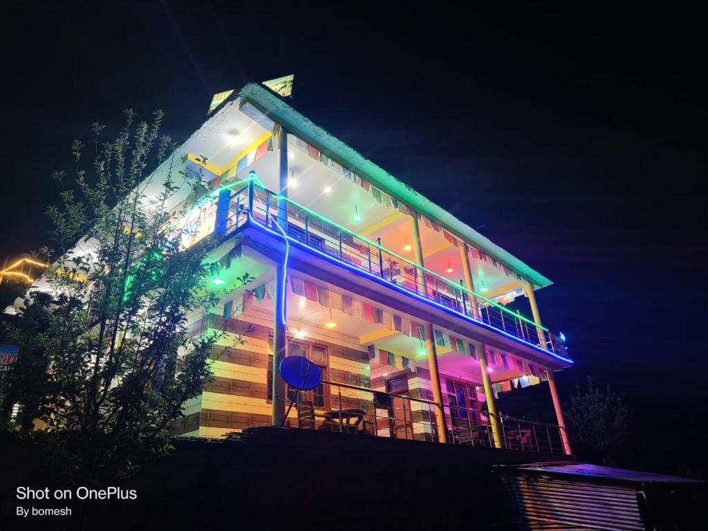 a building with lights on it at night at Gold star guest house and cafe in Tosh
