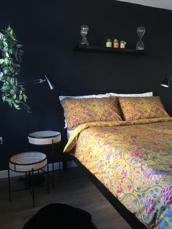 een slaapkamer met een bed en twee tafels en een lamp bij Comfortable rooms with live in host, walking distance to the High St & more in Glastonbury