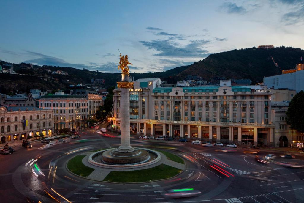 a city with a statue in the middle of a street at Courtyard by Marriott Tbilisi in Tbilisi City