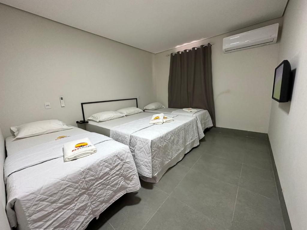 dwa łóżka w pokoju hotelowym z telewizorem w obiekcie Hotel Fly - Aeroporto Cuiabá w mieście Várzea Grande