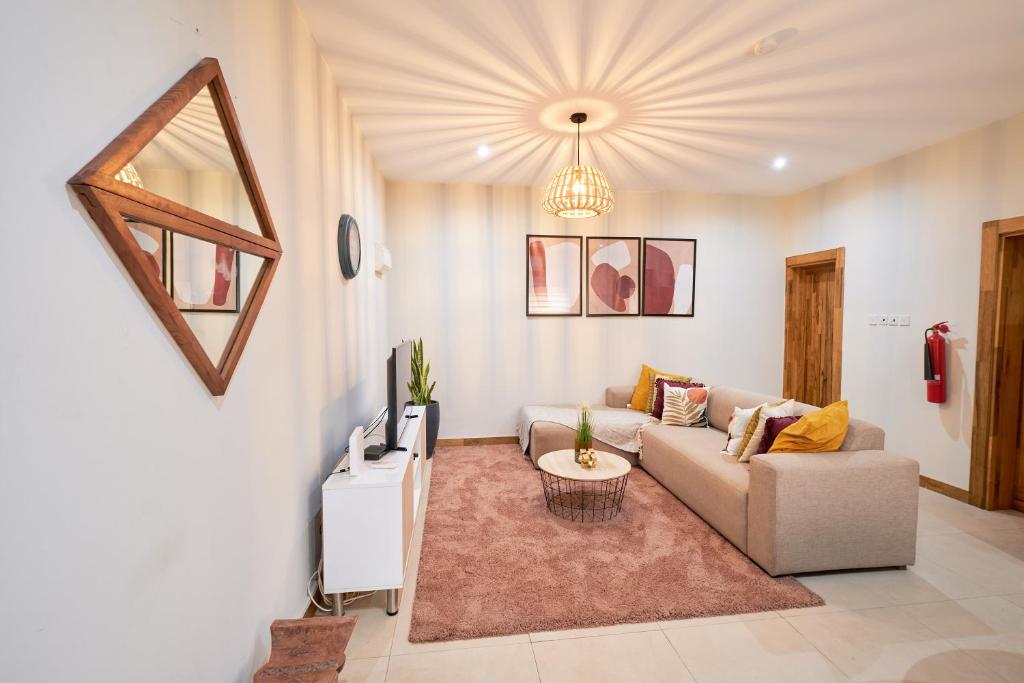 ein Wohnzimmer mit einem Sofa und einem TV in der Unterkunft The Avery at Windsor Apartments, Osu in Accra