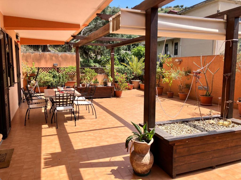 un patio con mesa, sillas y sombrilla en La casa dell'Asparago en Messina