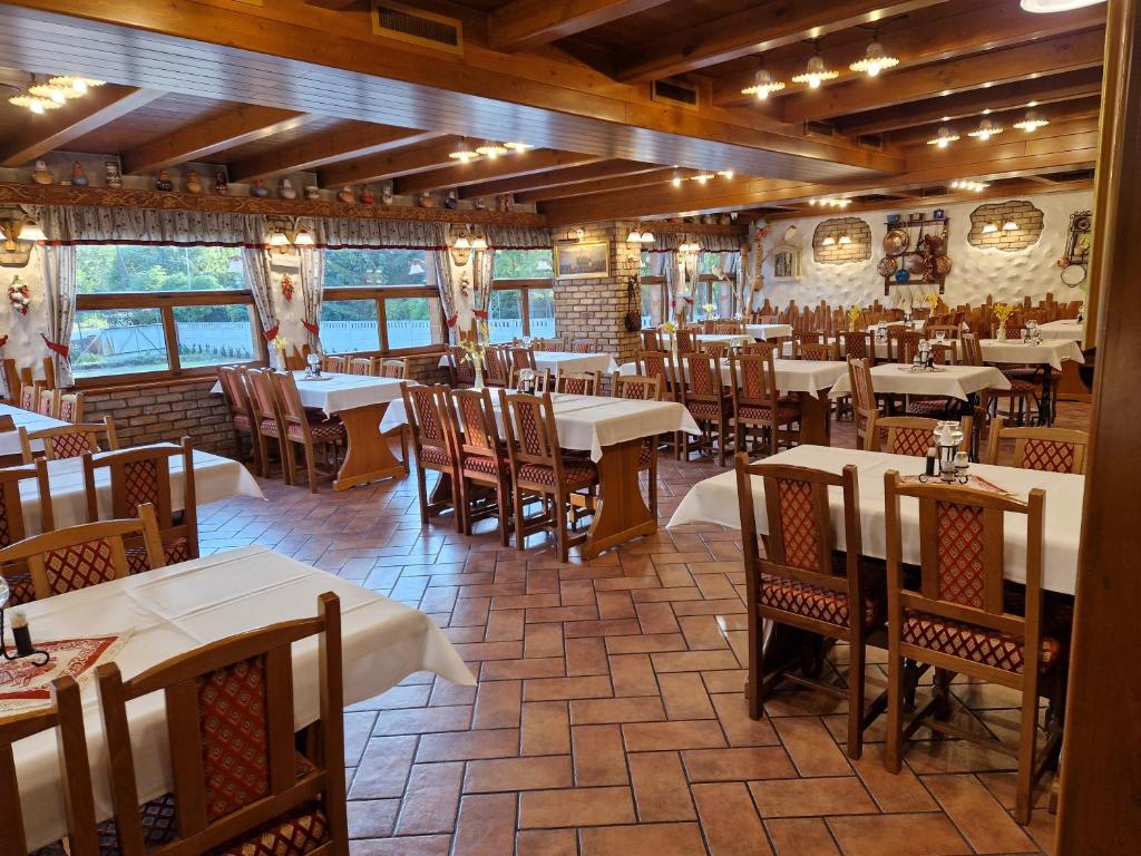 a restaurant with tables and chairs in a room at Csalánosi Vendégház in Kecskemét