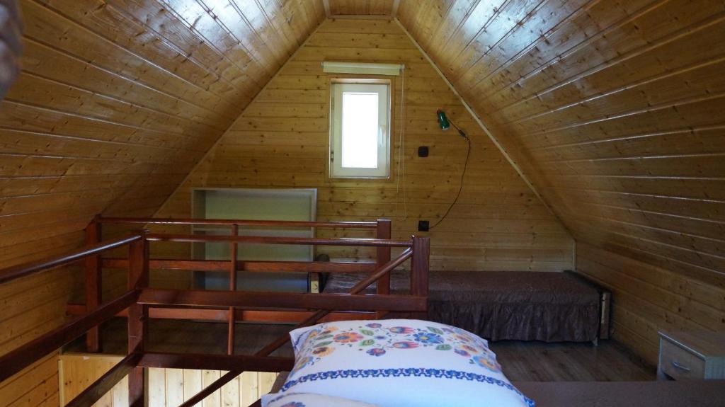 Habitación con cama en una cabaña de madera en Gospodarstwo Agroturystyczne Na Górce Domek 1, en Myczkowce