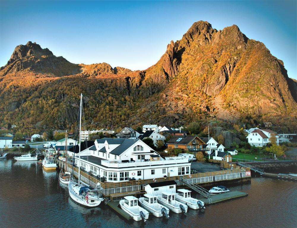 um grupo de barcos ancorados numa doca com uma montanha em Lofoten Rorbuer em Svolvær