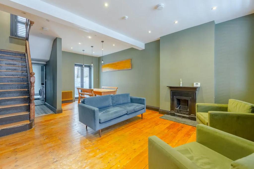 a living room with a blue couch and a fireplace at Inviting 4BD with Private Patio - Bethnal Green in London